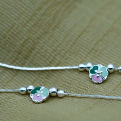 Design & Aesthetic Appeal of the Floral Anklet The Sterling Silver Floral Anklet features a minimal yet charming design. Key highlights include: Pastel enamel floral centerpiece (green and pink tones) Smooth silver bead accents adding texture Sleek and lightweight chain design Balanced and symmetrical layout The soft color palette gives the anklet a calm, elegant, and feminine appeal. Craftsmanship & Precision Detailing Each Sterling Silver Floral Anklet is crafted with attention to detail. Features include: High-quality enamel work for smooth color finish Polished sterling silver beads Securely attached floral charm Adjustable clasp for a comfortable fit The combination of enamel and silver detailing ensures durability and refined aesthetics. 925 Sterling Silver Quality & Purity This anklet is made from 925 sterling silver, offering strength and lasting shine. Benefits include: 92.5% pure silver composition Hypoallergenic and safe for sensitive skin Durable for daily wear Retains shine with proper care Learn more about silver standards: https://www.gia.edu/silver-jewelry The Sterling Silver Floral Anklet delivers both quality and elegance. Styling the Sterling Silver Floral Anklet This anklet is versatile and easy to pair. Everyday Styling Casual outfits Office wear (subtle styling) Minimal fashion Soft Feminine Styling Summer dresses Pastel outfits Ethnic wear Pairs beautifully with: Flats, sandals, or heels Light-colored outfits Minimal jewellery combinations It enhances your look without overpowering it. Perfect Occasions to Wear The Sterling Silver Floral Anklet is ideal for: Daily wear Casual outings Festive occasions Vacations Gifting Its soft and elegant design makes it suitable for all age groups. Durability & Comfortable Wear Designed for everyday comfort: Lightweight construction Flexible chain design Secure clasp closure Strong bead and charm attachment This ensures a comfortable and reliable wearing experience. Care Instructions for Silver Anklets To maintain your Sterling Silver Floral Anklet: Store in a dry jewellery box Avoid exposure to water and chemicals Clean with a soft cloth Remove before bathing or swimming For more care guidance: https://www.britannica.com/science/silver A Gentle Touch of Elegance The Sterling Silver Floral Anklet is a subtle yet beautiful accessory that reflects grace, simplicity, and soft charm. Its pastel tones and minimal design make it a timeless addition to your jewellery collection.