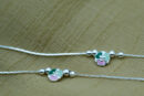Design & Aesthetic Appeal of the Floral Anklet The Sterling Silver Floral Anklet features a minimal yet charming design. Key highlights include: Pastel enamel floral centerpiece (green and pink tones) Smooth silver bead accents adding texture Sleek and lightweight chain design Balanced and symmetrical layout The soft color palette gives the anklet a calm, elegant, and feminine appeal. Craftsmanship & Precision Detailing Each Sterling Silver Floral Anklet is crafted with attention to detail. Features include: High-quality enamel work for smooth color finish Polished sterling silver beads Securely attached floral charm Adjustable clasp for a comfortable fit The combination of enamel and silver detailing ensures durability and refined aesthetics. 925 Sterling Silver Quality & Purity This anklet is made from 925 sterling silver, offering strength and lasting shine. Benefits include: 92.5% pure silver composition Hypoallergenic and safe for sensitive skin Durable for daily wear Retains shine with proper care Learn more about silver standards: https://www.gia.edu/silver-jewelry The Sterling Silver Floral Anklet delivers both quality and elegance. Styling the Sterling Silver Floral Anklet This anklet is versatile and easy to pair. Everyday Styling Casual outfits Office wear (subtle styling) Minimal fashion Soft Feminine Styling Summer dresses Pastel outfits Ethnic wear Pairs beautifully with: Flats, sandals, or heels Light-colored outfits Minimal jewellery combinations It enhances your look without overpowering it. Perfect Occasions to Wear The Sterling Silver Floral Anklet is ideal for: Daily wear Casual outings Festive occasions Vacations Gifting Its soft and elegant design makes it suitable for all age groups. Durability & Comfortable Wear Designed for everyday comfort: Lightweight construction Flexible chain design Secure clasp closure Strong bead and charm attachment This ensures a comfortable and reliable wearing experience. Care Instructions for Silver Anklets To maintain your Sterling Silver Floral Anklet: Store in a dry jewellery box Avoid exposure to water and chemicals Clean with a soft cloth Remove before bathing or swimming For more care guidance: https://www.britannica.com/science/silver A Gentle Touch of Elegance The Sterling Silver Floral Anklet is a subtle yet beautiful accessory that reflects grace, simplicity, and soft charm. Its pastel tones and minimal design make it a timeless addition to your jewellery collection.