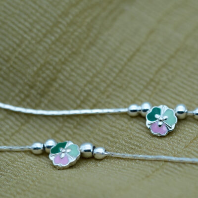 Design & Aesthetic Appeal of the Floral Anklet The Sterling Silver Floral Anklet features a minimal yet charming design. Key highlights include: Pastel enamel floral centerpiece (green and pink tones) Smooth silver bead accents adding texture Sleek and lightweight chain design Balanced and symmetrical layout The soft color palette gives the anklet a calm, elegant, and feminine appeal. Craftsmanship & Precision Detailing Each Sterling Silver Floral Anklet is crafted with attention to detail. Features include: High-quality enamel work for smooth color finish Polished sterling silver beads Securely attached floral charm Adjustable clasp for a comfortable fit The combination of enamel and silver detailing ensures durability and refined aesthetics. 925 Sterling Silver Quality & Purity This anklet is made from 925 sterling silver, offering strength and lasting shine. Benefits include: 92.5% pure silver composition Hypoallergenic and safe for sensitive skin Durable for daily wear Retains shine with proper care Learn more about silver standards: https://www.gia.edu/silver-jewelry The Sterling Silver Floral Anklet delivers both quality and elegance. Styling the Sterling Silver Floral Anklet This anklet is versatile and easy to pair. Everyday Styling Casual outfits Office wear (subtle styling) Minimal fashion Soft Feminine Styling Summer dresses Pastel outfits Ethnic wear Pairs beautifully with: Flats, sandals, or heels Light-colored outfits Minimal jewellery combinations It enhances your look without overpowering it. Perfect Occasions to Wear The Sterling Silver Floral Anklet is ideal for: Daily wear Casual outings Festive occasions Vacations Gifting Its soft and elegant design makes it suitable for all age groups. Durability & Comfortable Wear Designed for everyday comfort: Lightweight construction Flexible chain design Secure clasp closure Strong bead and charm attachment This ensures a comfortable and reliable wearing experience. Care Instructions for Silver Anklets To maintain your Sterling Silver Floral Anklet: Store in a dry jewellery box Avoid exposure to water and chemicals Clean with a soft cloth Remove before bathing or swimming For more care guidance: https://www.britannica.com/science/silver A Gentle Touch of Elegance The Sterling Silver Floral Anklet is a subtle yet beautiful accessory that reflects grace, simplicity, and soft charm. Its pastel tones and minimal design make it a timeless addition to your jewellery collection.